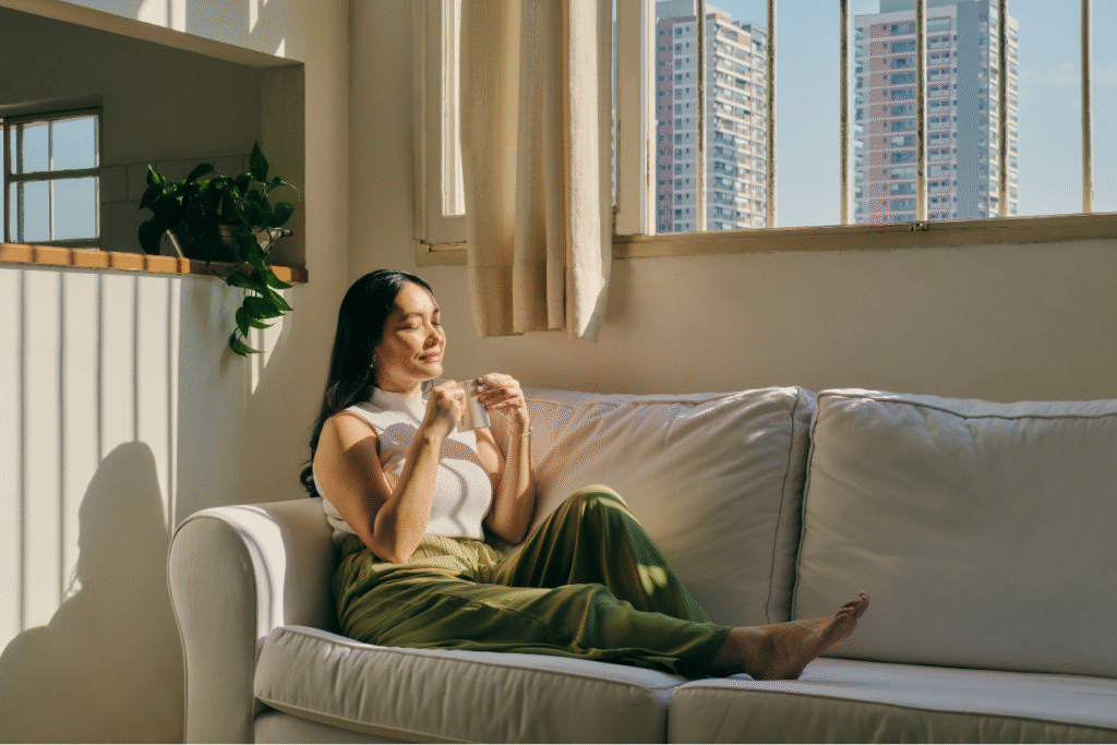 明るい部屋でリラックスしながら日差しを浴びる女性