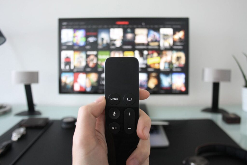 ひとりでテレビを見るためにリモコンを操作する手