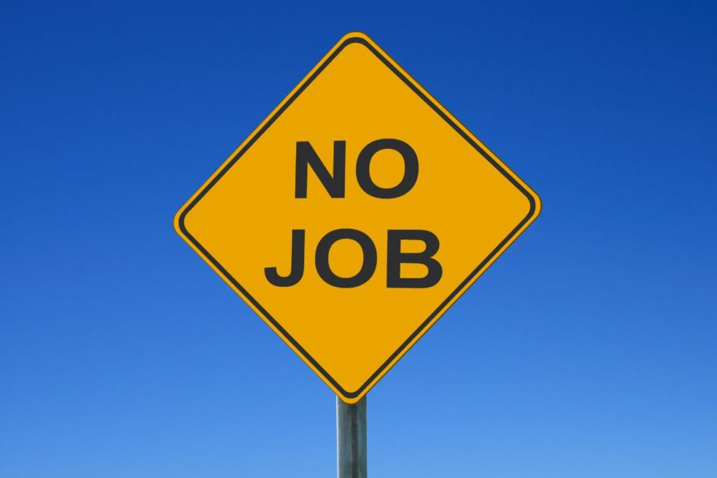青空の下に立つ黄色い警告標識に『NO JOB』の文字。