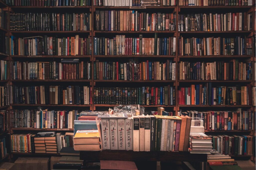 壁一面を埋め尽くす本棚に、びっしりと古い洋書が並ぶ書斎。専門家の深い知識や長年の研究、歴史の積み重ねを象徴するイメージ