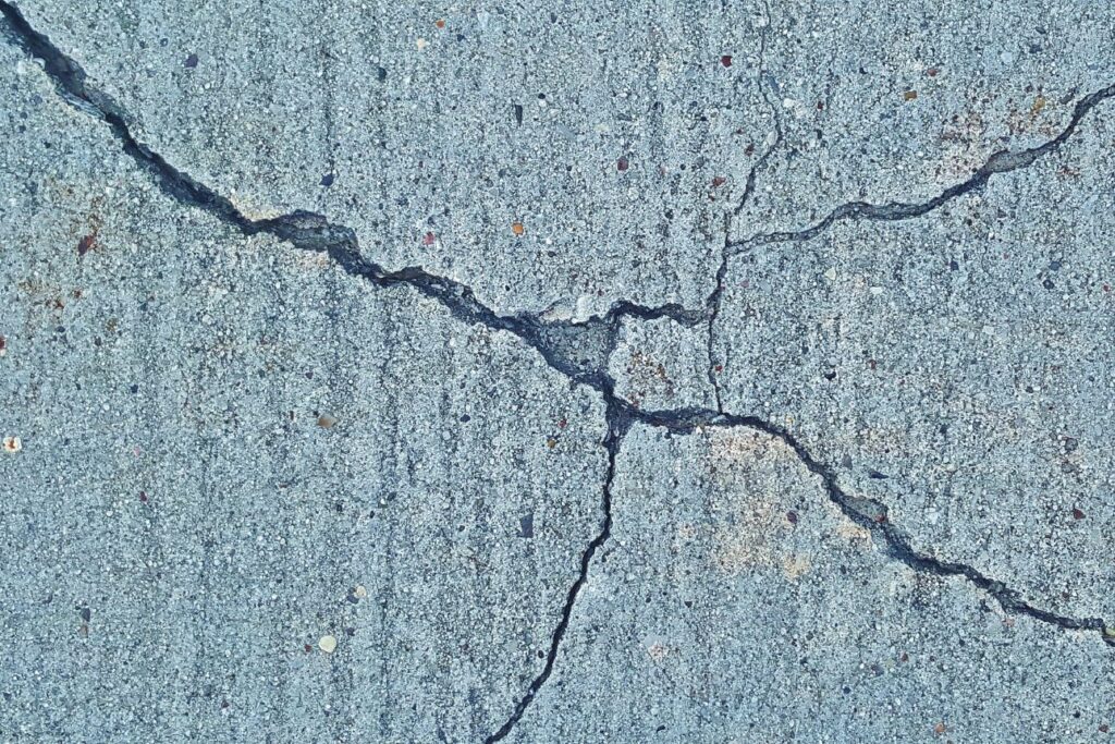 表面に大きなひび割れがあるコンクリートの地面