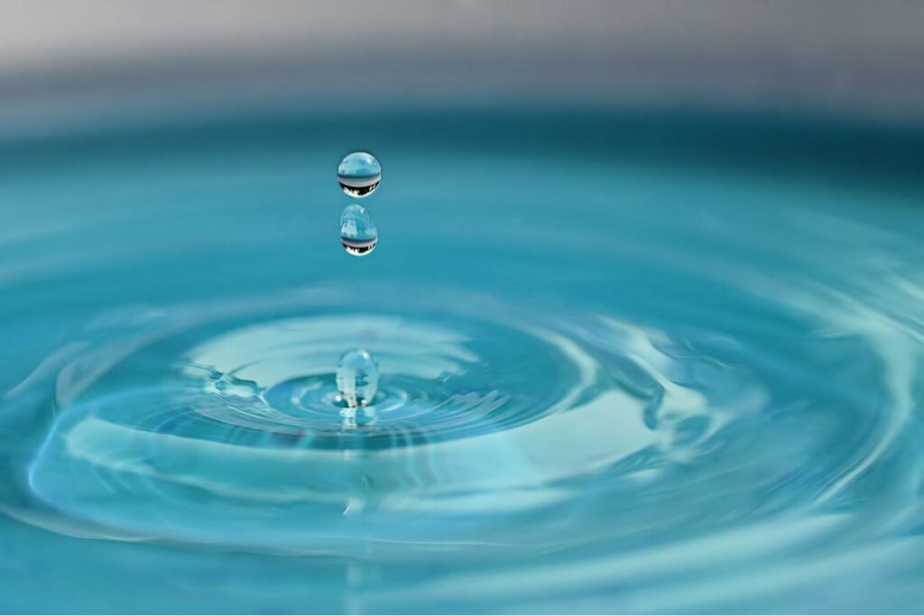 水面に落ちる2滴のしずくと広がる波紋のクローズアップ