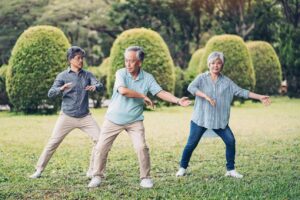公園で太極拳を練習するシニアの男女。