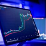 暗いブルーの部屋で光るトレーディング画面に表示された株価チャートとテクニカル指標