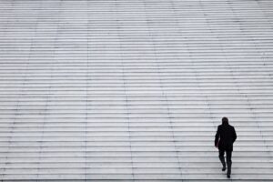 孤独な道を一歩ずつ登る後ろ姿の男性