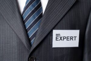 スーツの胸元にMR. EXPERTと書かれた名札。